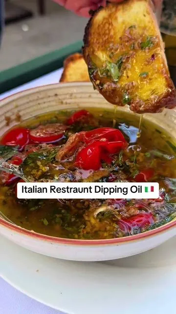 🇮🇹 Italian Restaurant Olive Oil Dip:  Ingredients: - Traditional Extra Virgin Olive Oil 🫒 - Fresh Cherry Tomatoes, halved 🍅 - Fragrant Herbs (like basil, oregano, thyme) 🌿 - A pinch of Chili Flakes for heat 🌶️ - Roasted Garlic, smashed 🧄 - Shaved Parmesan Cheese 🧀 - A drizzle of Aged Balsamic Vinegar 🍇 Instructions: Pour olive oil into a shallow dish. Layer in halved cherry tomatoes and smashed roasted garlic. Sprinkle in herbs and chili flakes. Add shaved Parmesan over the top. Finish with a generous drizzle of aged balsamic.  Grab your favorite  bread and dip right in! Buon appetito!